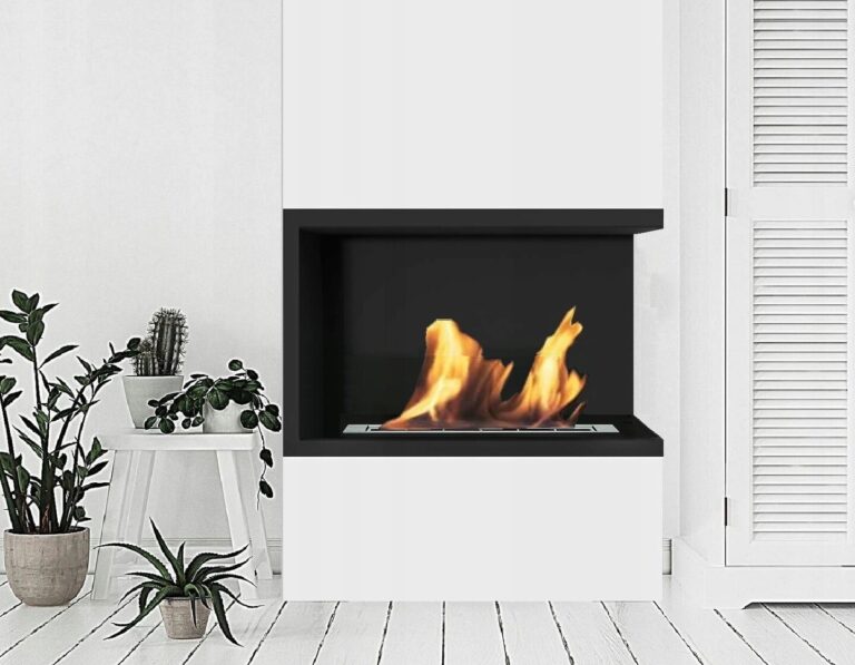 Black corner bioethanol fireplace recessed in a white wall beside potted plants