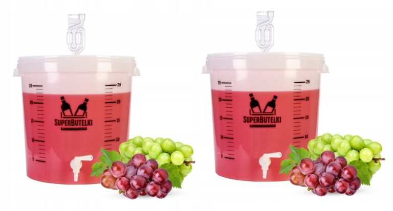 Two lidded fermenting buckets with taps and airlocks, pictured with red liquid and grapes